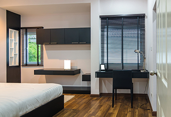 Hotel room with black vinyl blinds and grey curtains for window coverings
