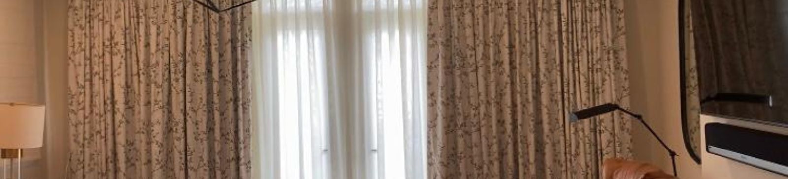 Close-up of custom curtains and blackout drapes providing total privacy in a modern Newport Beach bedroom.